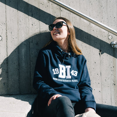 Woman wearing navy blue hoodie with BI logo